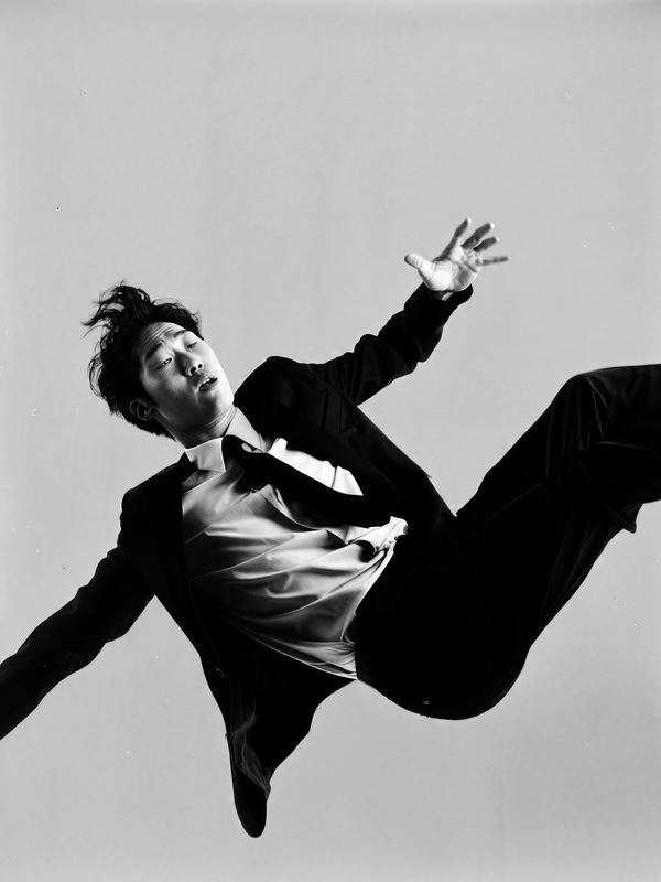 A man in a suit falling backwards through the air. A black-and-white picture in a 1960s studio style.
